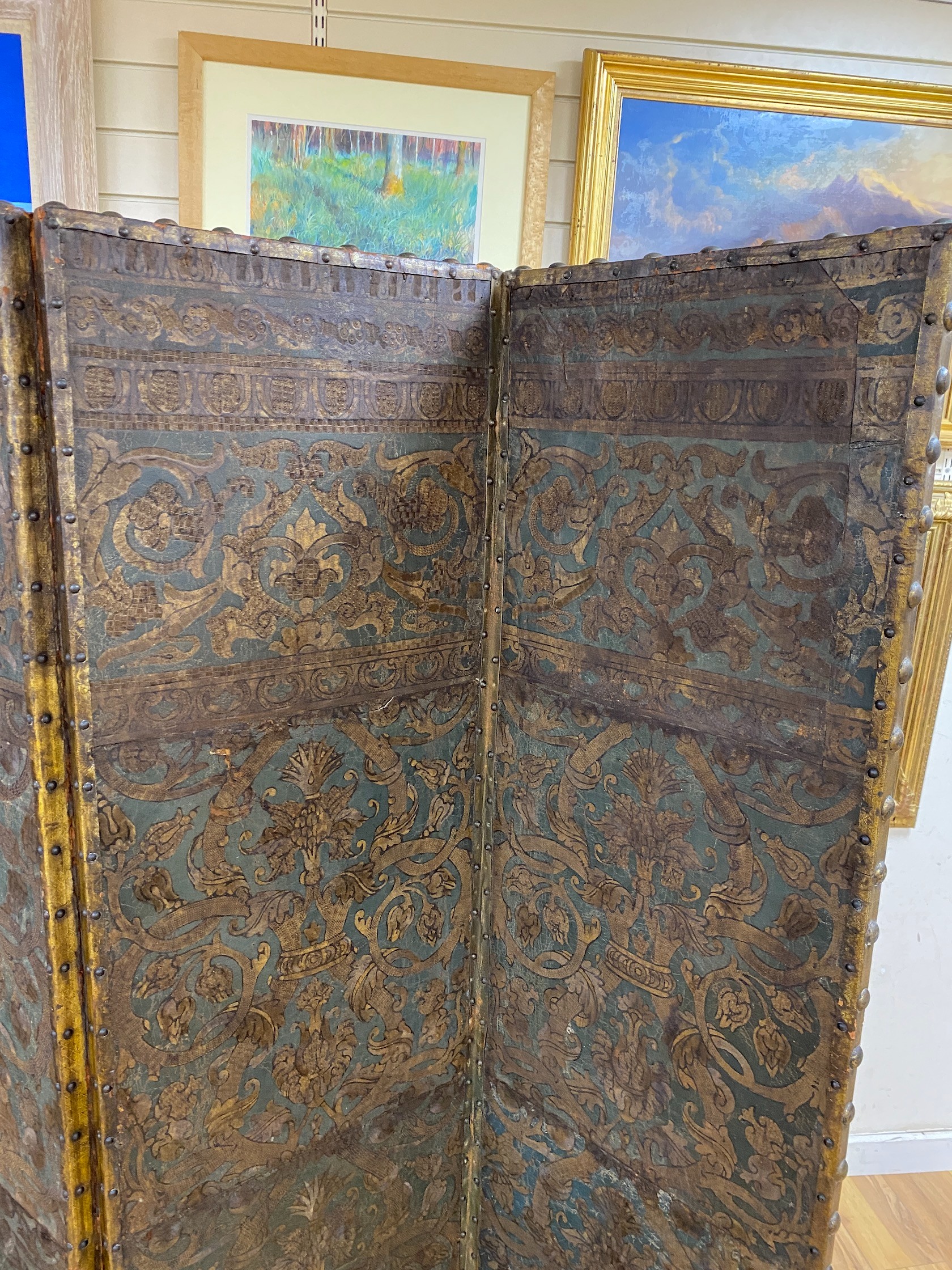 A 19th century French studded leather four fold screen, each panel width 49cm, height 182cm